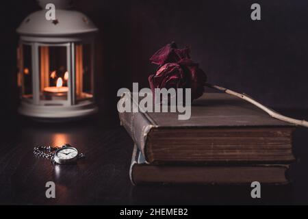 Vintage Still Life of Rose su vecchi libri con orologio e lanterna Foto Stock