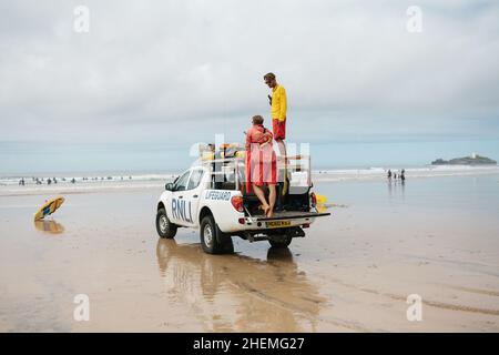 I bagnini RNLI osservano la sicurezza dei bagnanti e dei surfisti dall'alto punto panoramico della loro 4x4 sulla spiaggia di Gwitian vicino a St Ives, Cornovaglia. Foto Stock