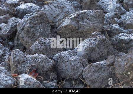 Primo piano di terra arata un sottile strato di gelo su di esso. Foto Stock