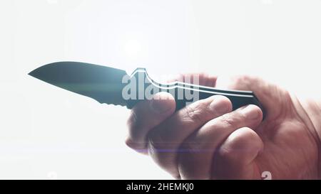 Coltello affilato in mano maschio. Lama di apertura coltello tasca pieghevole automatica EDC su sfondo bianco con lente svasata. Foto Stock