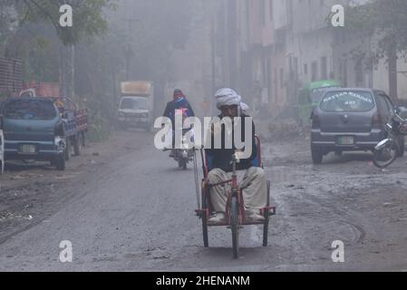 Lahore. Pakistan, 11/10/2022, cittadini pakistani, studenti in viaggio durante una fredda e densa mattinata di nebbia a Lahore. I residenti e i pendolari pakistani sono più preoccupati che sorpresi a causa dell'improvviso strato di smog denso che sta causando problemi di respirazione, visibilità e ha anche ostacolato il flusso regolare del traffico; I residenti di Lahore si svegliarono fino ad una densa coperta di smog il Giovedi che ha ridotto la visibilità per i pendolari e ha spinto diverse lamentele di problemi respiratori e angoscia mentale. (Foto di Rana Sajid Hussain/Pacific Press) Foto Stock