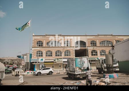 Gibuti, Gibuti - 21 maggio 2021: Bandiera di Gibuti e un edificio a Gibuti. Una strada a Gibuti. Scatto editoriale a Gibuti. Foto Stock