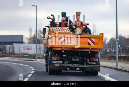 Chemnitz, Germania. 11th Jan 2022. Due grandi figure 'Angel' e 'Miner' sono trasportati via dal centro della città da un camion della città di Chemnitz. Le due figure tradizionali sono state integrate negli ultimi anni da un rompigranella a grandezza naturale e da un pupazzo di neve. Fanno parte della decorazione del mercato di Natale di Chemnitz, accanto alla piramide di Natale alta 12 metri e ad un arco di candela alto 5 metri. Tutti i pezzi sono stati creati da artigiani dei Monti ore. Credit: Jan Woitas/dpa-Zentralbild/ZB/dpa/Alamy Live News Foto Stock