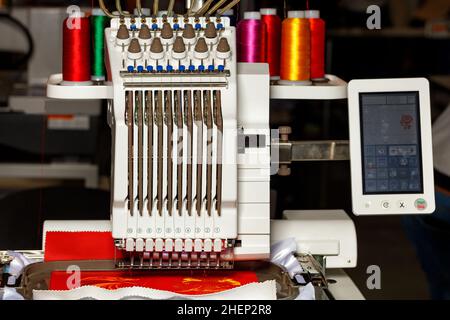 Ricamo a filo multicolore programmabile al lavoro. Primo piano. Spazio di copia. Foto Stock