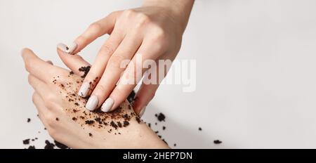 Donna che applica la macchia di caffè alla sua mano, vista ravvicinata Foto Stock