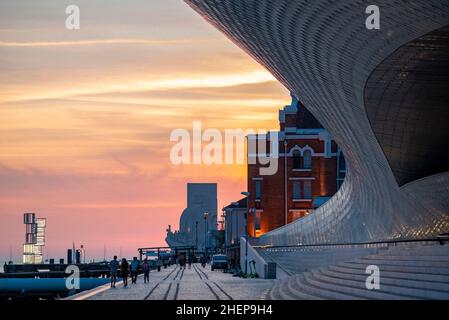 Tramonto sul lungomare con IL MAAT e il monumento delle scoperte o Pedaro dos Descobrimentos a Belem vicino alla città di Lisbona in Portogallo. Porta Foto Stock