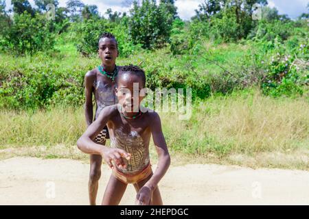 Aggressivo Hamer Tribe persone sulla strada rurale verde Foto Stock