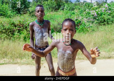 Aggressivo Hamer Tribe persone sulla strada rurale verde Foto Stock