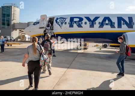 I passeggeri che camminano per salire a bordo di un aereo Ryanair Boeing 737 Jet Airliner all'aeroporto di Alicante Elche, Costa Blanca, Spagna, UE, in una luminosa giornata di sole. Anteriore Foto Stock