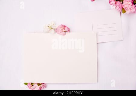 Primavera delicato cartolina con posto per indirizzo e carta di cancelleria mock up con fiori rosa e bianco. Giornata della donna, invito, romantico, matrimonio, compleanno, Il concetto di scheda del giorno della madre. Spazio di copia Foto Stock