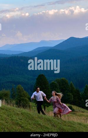 Vorokhta, Ucraina 28 luglio 2021:un ragazzo con una ragazza che cammina nei prati di montagna, pittoreschi e misteriosi Carpazi ucraini, le cime dei Carpazi Foto Stock