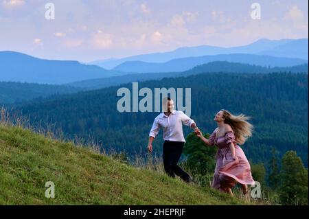 Vorokhta, Ucraina 28 luglio 2021:un ragazzo con una ragazza che cammina nei prati di montagna, pittoreschi e misteriosi Carpazi ucraini, le cime dei Carpazi Foto Stock