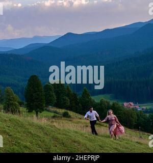 Vorokhta, Ucraina 28 luglio 2021:un ragazzo con una ragazza che cammina nei prati di montagna, pittoreschi e misteriosi Carpazi ucraini, le cime dei Carpazi Foto Stock