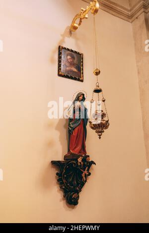 L'icona è appesa sopra la statua della Vergine Maria su un supporto scolpito nella parete del tempio Foto Stock