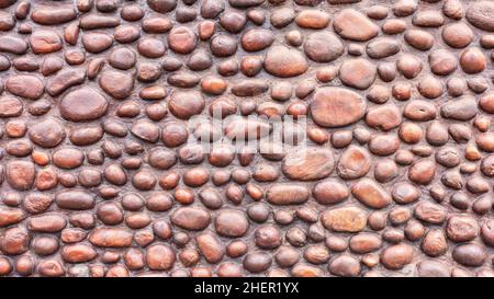 Decorazioni a parete design costruzione di pietre rotonde fiume forme e dimensioni per una struttura unica costruita a mano all'aperto. Foto Stock