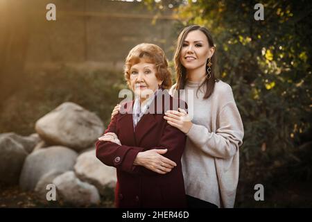 Bella figlia alta con sua madre nella caduta nel parco tra gli alberi. Foto di alta qualità Foto Stock