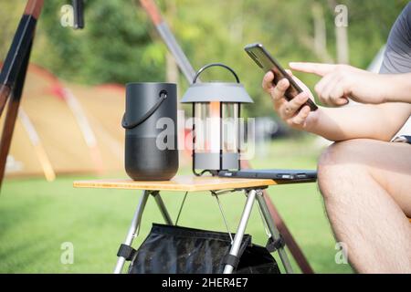 Uomini che utilizzano un altoparlante intelligente con smartphone. Foto Stock