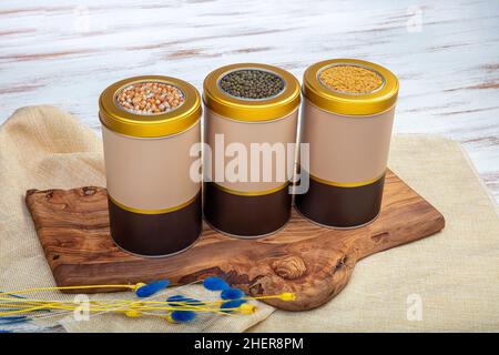 Contenitori di deposito di legume in varie misure. Vasetti di latta con vari tipi di mais, fagioli, cereali, per immagazzinare e decorare la cucina. Foto Stock