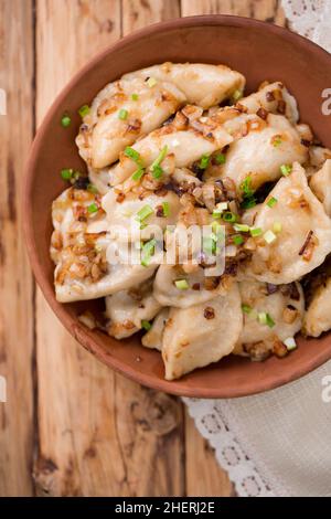 Gnocchi ucraini con pancetta fritta e cipolle in stile rustico Foto Stock