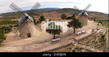 Panoramica veduta aerea dall'alto di due antichi mulini a vento recuperati sulla cima di una collina in Alcublas, Spagna Foto Stock