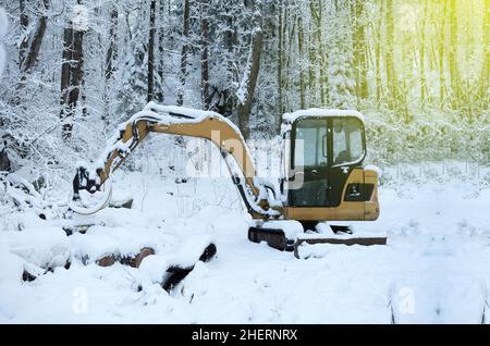 Escavatore che rimuove la neve dalla strada in inverno Foto Stock