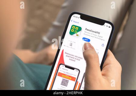 Kharkov, Ucraina - 10 gennaio 2022: Primo piano dell'icona di PassCovidTG app. Donna con applicazione su Apple iPhone 12 Foto Stock