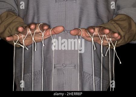 Burattinaio tiratore con camicia cinese, fotografia da studio con sfondo nero Foto Stock