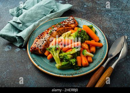 Primo piano della deliziosa bistecca di filetto di salmone alla griglia in salsa teriyaki con verdure arrostite Foto Stock