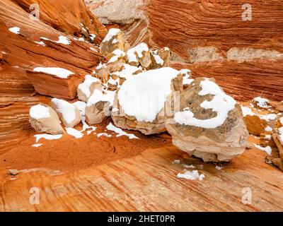 Neve su un balzo di massi in nicchia di roccia rossa nella zona di White Pocket del Vermilion Cliffs National Monument, Arizona. Foto Stock