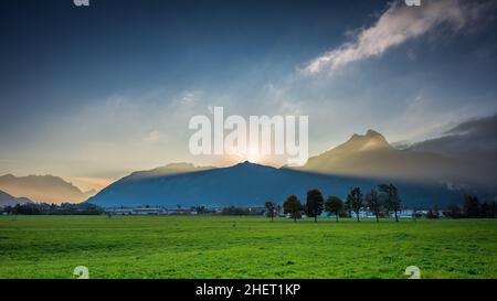 volume luci fasci di sole al tramonto dietro la cima della catena di montagna in austria vacanza Foto Stock