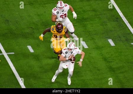 Il quarterback dei badgers del Wisconsin Graham Mertz (5) è pressurizzato dal lineman difensivo B.J. del Sun di Arizona state Devils Green II (35) durante il Las Vegas Bowl Foto Stock