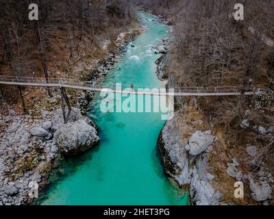 1 persone in piedi su un ponte sul bellissimo fiume Soca blu cristallo sulla strada per la caduta di Kozjak in Slovenia, Europa Foto Stock