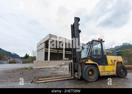 carrello elevatore giallo con carrello in piedi presso il magazzino Foto Stock