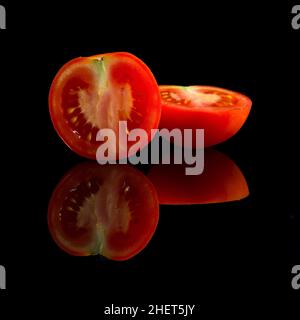 pomodoro rosso halfed fresco su sfondo nero Foto Stock