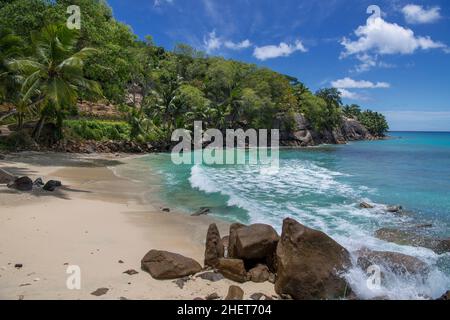 Piccola spiaggia e costa occidentale rocciosa Mahe Seychelles Foto Stock