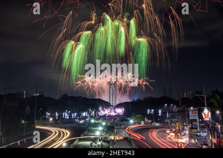 Manila, Filippine. 1st Jan 2022. I percorsi delle luci dell'auto illuminano le strade di Manila, mentre un colorato spettacolo di fuochi d'artificio illumina il cielo sopra il Quezon City Memorial Circle per inaugurare il nuovo anno nelle Filippine. Credit: Basilio Sepe/ZUMA Wire/ZUMAPRESS.com/Alamy Live News Foto Stock