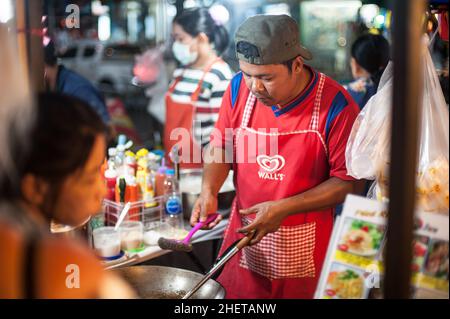 PHUKET, TAILANDIA - 10. MARZO 2018. Un venditore asiatico non identificato prepara il cibo per strada. Pad Thai. Foto editoriale del giorno Foto Stock