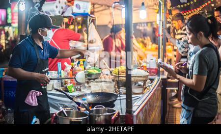 PHUKET, TAILANDIA - 10. MARZO 2018. Un venditore asiatico non identificato prepara il cibo per strada. Pad Thai. Foto editoriale del giorno Foto Stock