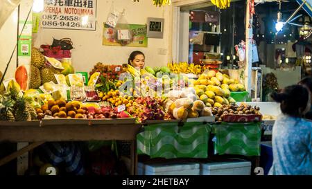 PHUKET, TAILANDIA - 10. MARZO 2018. Un venditore asiatico non identificato che vende frutta fresca tropicale ed esotica per strada. Foto editoriale del giorno Foto Stock