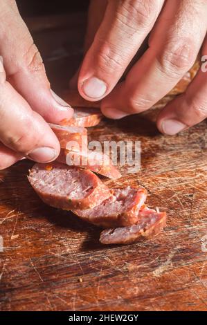 Affettato ​​smoked salsiccia di calabrese in un tavolo di legno, spazio copia Foto Stock