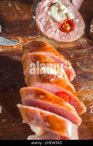 Salsiccia e peperoni, salsiccia artigianale con formaggio e pepe su un asse di legno, spazio copia e fuoco selettivo Foto Stock