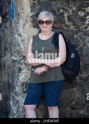 Woan in posa contro muro di pietra a Puerto Rico in vacanza Foto Stock