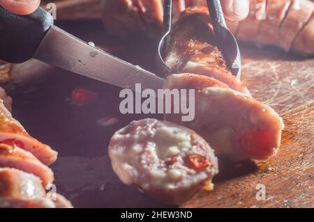 Salsiccia e peperoni, salsiccia artigianale con formaggio e pepe su un asse di legno, spazio copia e fuoco selettivo Foto Stock