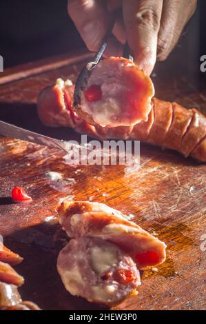 Salsiccia e peperoni, salsiccia artigianale con formaggio e pepe su un asse di legno, spazio copia e fuoco selettivo Foto Stock