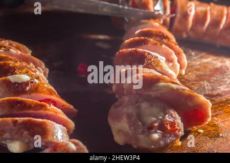 Salsiccia e peperoni, salsiccia artigianale con formaggio e pepe su un asse di legno, spazio copia e fuoco selettivo Foto Stock