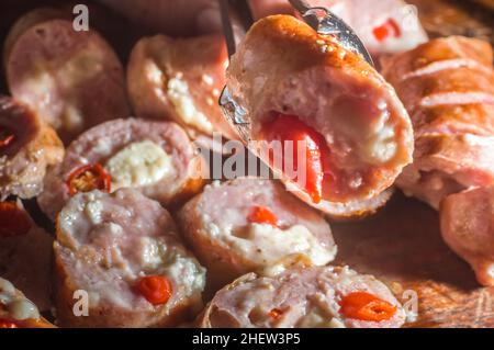 Salsiccia e peperoni, salsiccia artigianale con formaggio e pepe su un asse di legno, spazio copia e fuoco selettivo Foto Stock