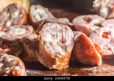 Salsiccia e peperoni, salsiccia artigianale con formaggio e pepe su un asse di legno, spazio copia e fuoco selettivo Foto Stock