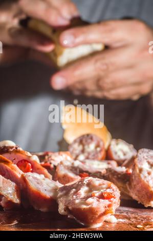 Salsiccia e peperoni, salsiccia artigianale con formaggio e pepe su un asse di legno, spazio copia e fuoco selettivo Foto Stock