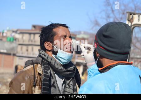 12 gennaio 2022, Poonch, Jammu e Kashmir, India: Un operatore sanitario raccoglie un campione di tampone di un bambino per il test Covid-19, a Mendhar. India segnala 1, 94.720 nuovi casi COVID, 60.405 recuperi e 442 morti nelle ultime 24 ore. (Credit Image: © Nazim Ali KhanZUMA Press Wire) Foto Stock