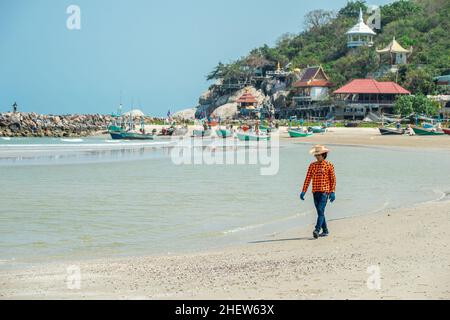 Uomo che cammina a Khao Tao Beach a Khao Tao a sud di Hua Hin, Prachuap Khiri Khan Provincia, Thailandia Foto Stock